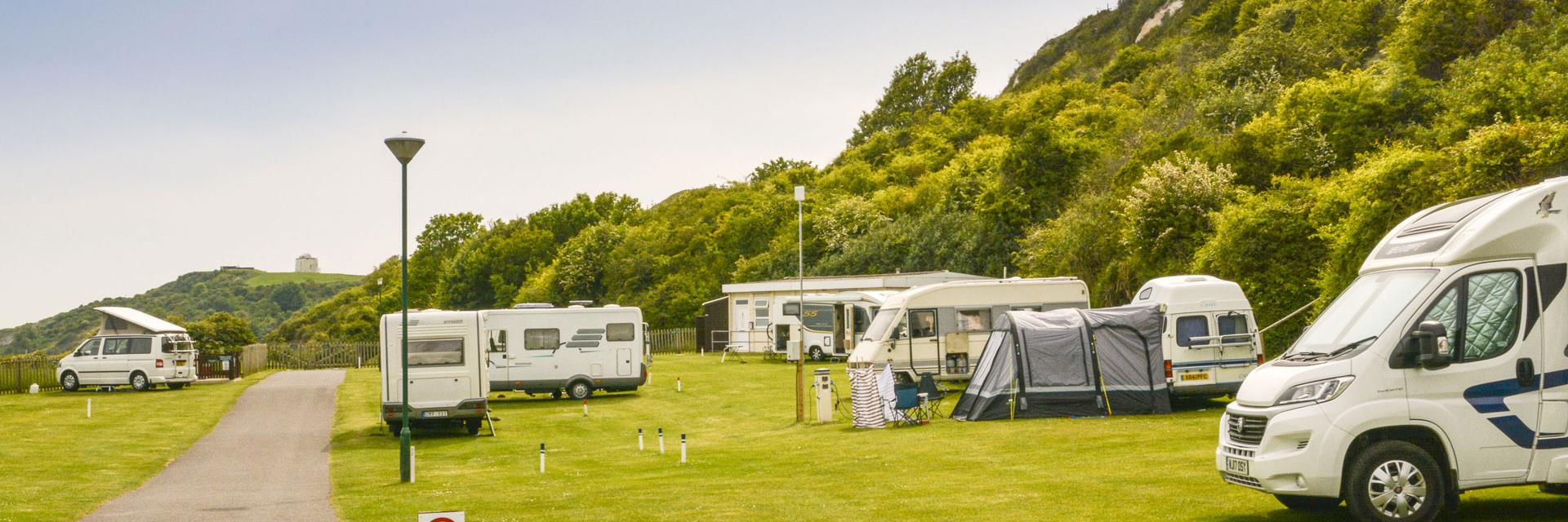 man and woman sitting in front of RV trailer